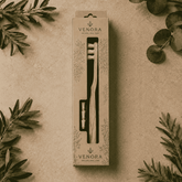 Venora toothbrush packaging on a beige background with green leaves