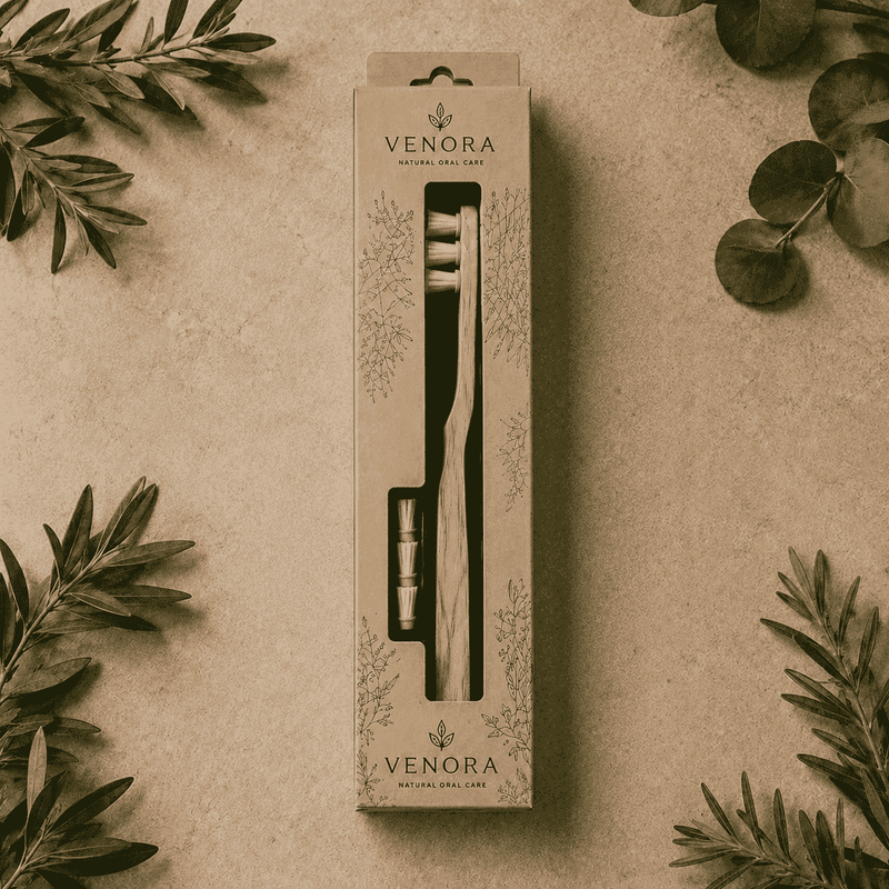 Venora toothbrush packaging on a beige background with green leaves